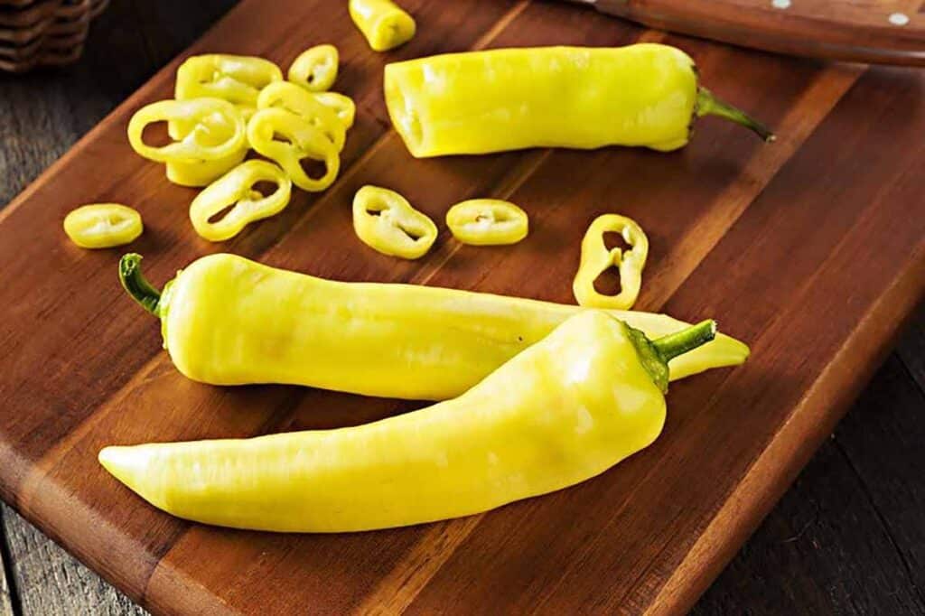 Cutting board with sliced banana peppers. 