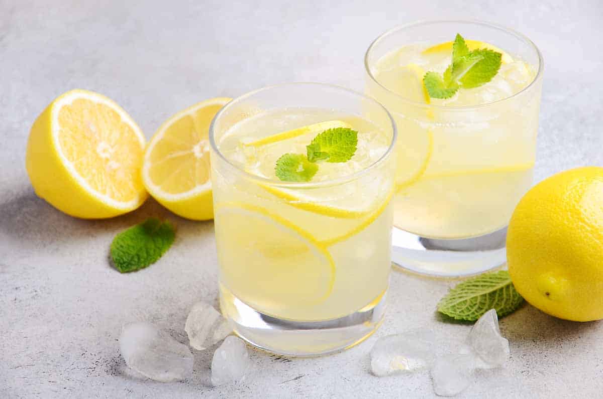 Glass with triple sec drink garnished with lemon. 